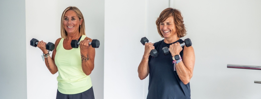 two-mature-sporty-women-smiling-while-doing-bicep-curls-with-weights-ways-to-stick-to-fitness-routine-for-mental-health